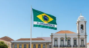 Bandeira de Florianópolis com fundo verde e amarelo, brasão central e nome da cidade em letras brancas.