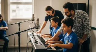 Professor ensina crianças a tocar teclado em sala de aula com microfone e instrumentos musicais.