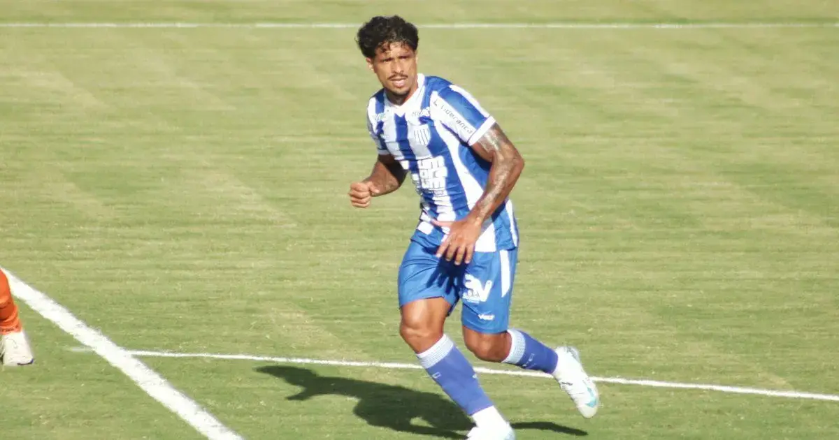 Jogador do Avaí em campo, vestindo uniforme azul e branco, correndo em direção à bola.