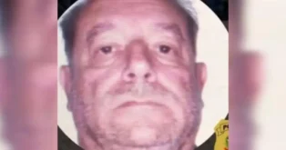 Retrato de homem com expressão séria, fundo desfocado e emoldurado por um círculo.