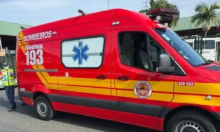 Viatura dos bombeiros em destaque, com sirene e logo de emergência, estacionada em área urbana.