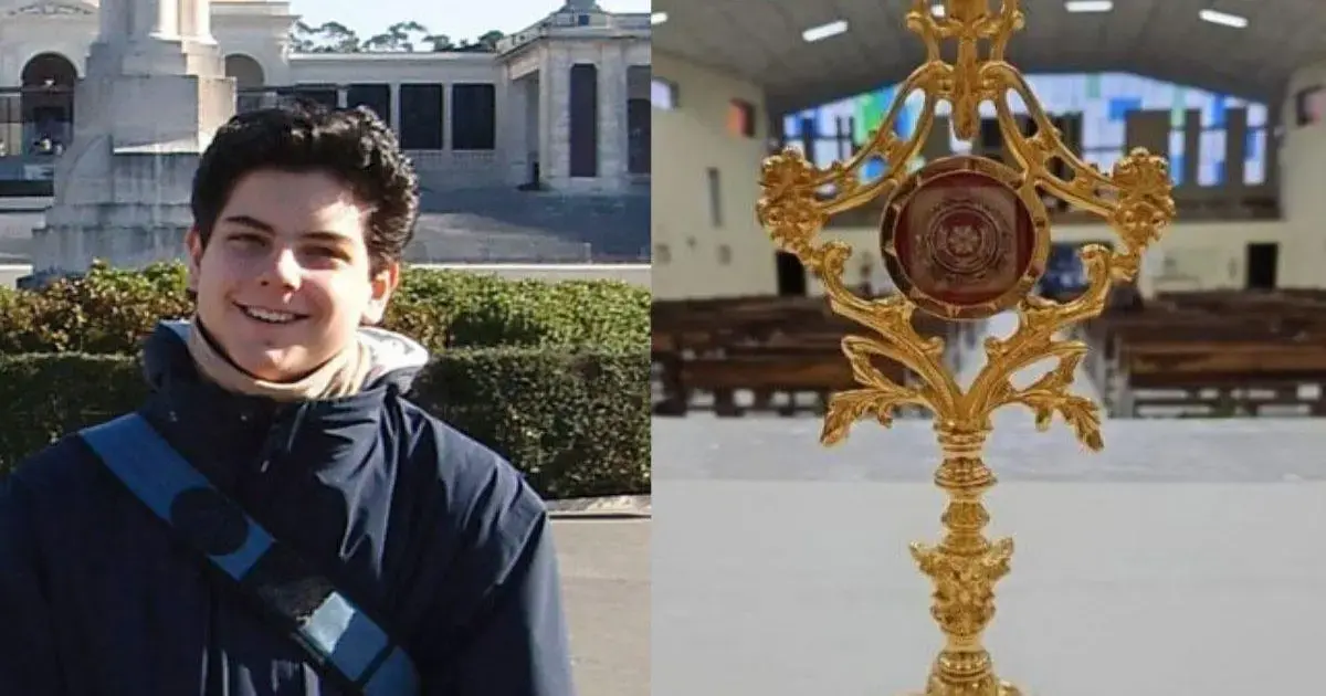 Jovem sorridente com casaco escuro ao lado de um ostensório dourado em ambiente religioso.