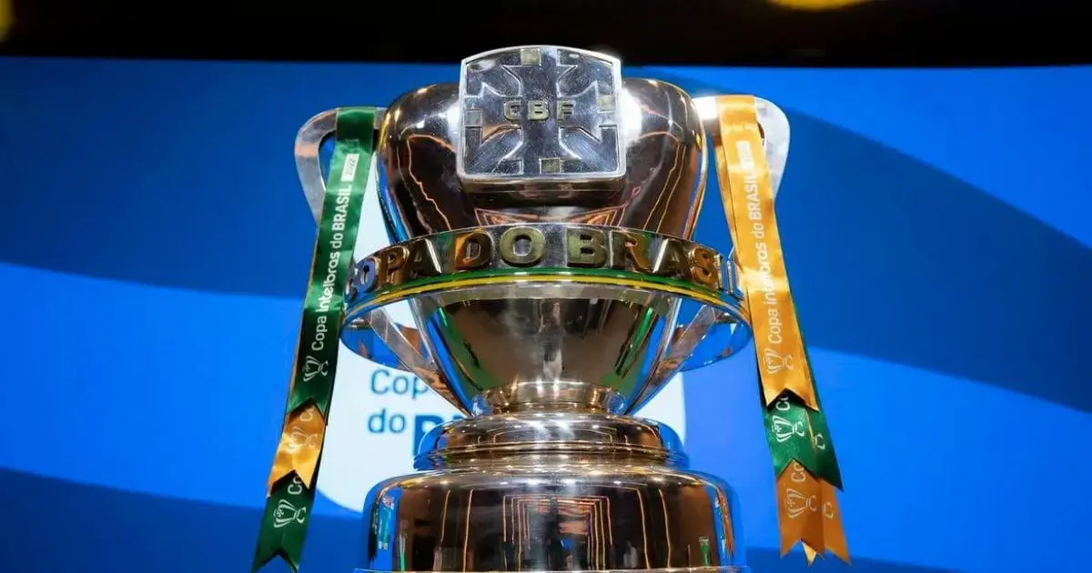 Copa do Brasil em troféu prateado com fitas verde e laranja ao fundo azul.