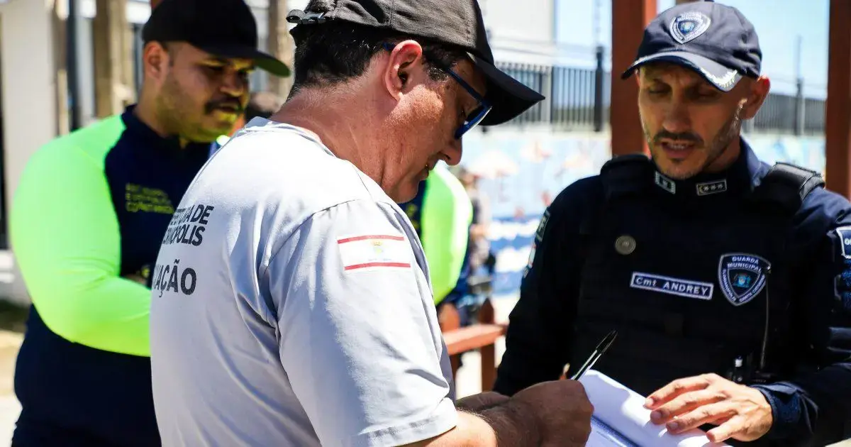 Homem assinando documento enquanto é abordado por agentes de segurança em Florianópolis.