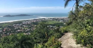 Vista panorâmica do Morro do Lampião, com vegetação, praias e áreas urbanas de Florianópolis ao fundo.