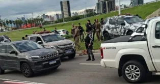 Forças de segurança em ação após tiroteio, veículos policiais e civis na área central de Florianópolis.