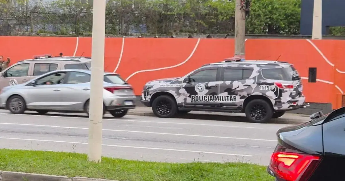 Viatura da Polícia Militar camuflada estacionada ao lado de carros em uma rua do Centro de Florianópolis.