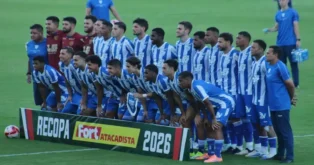 Elenco de time de futebol posando em campo com faixa escrito "RECOPA" e patrocínio visível.
