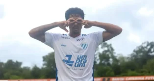Atleta vestindo camisa branca do Avaí FC, fazendo gesto com as mãos em forma de óculos.