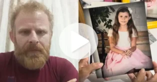 Homem com barba observa uma foto de uma menina sentada, vestindo um vestido rosa, em ambiente interno.