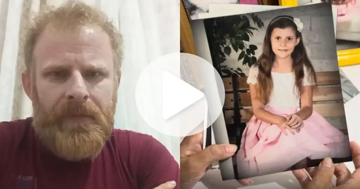 Homem com barba observa uma foto de uma menina sentada, vestindo um vestido rosa, em ambiente interno.