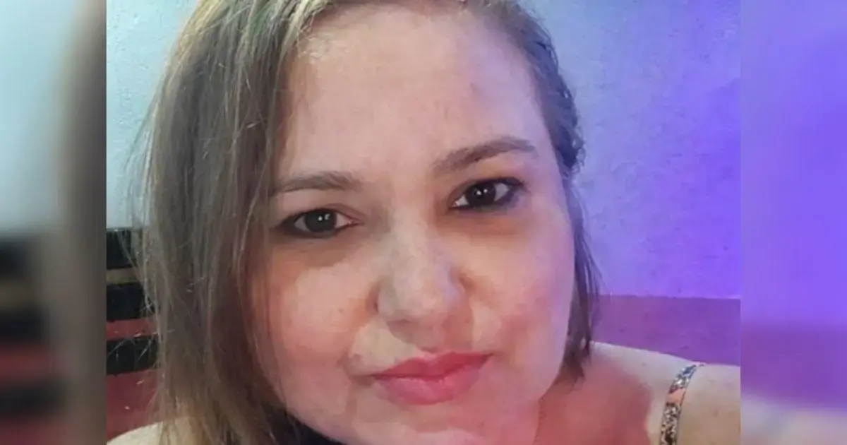 Retrato de uma mulher com cabelo liso e claro, sorrindo em um ambiente iluminado.