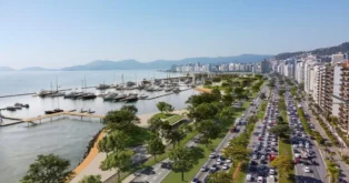 Vista panorâmica da Marina da Beira-Mar Norte, com barcos e edifícios ao fundo, em uma manhã ensolarada.