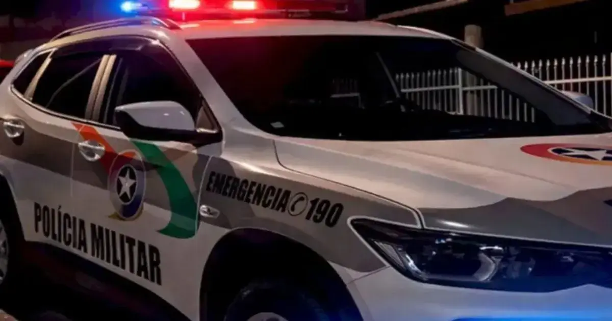 Veículo da Polícia Militar com sirenes ligadas, destacando a cor branca e detalhes em verde e vermelho.