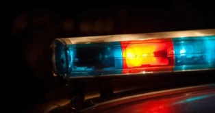 Luz de polícia em funcionamento com iluminação azul e vermelha em fundo escuro.