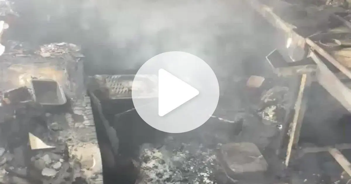 Ambiente de uma lanchonete após incêndio, com resíduos queimados e fumaça visível.