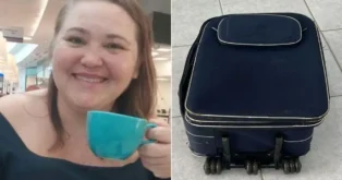 Uma mulher sorridente segura uma xícara azul, ao lado de uma mala preta em superfície de azulejos.