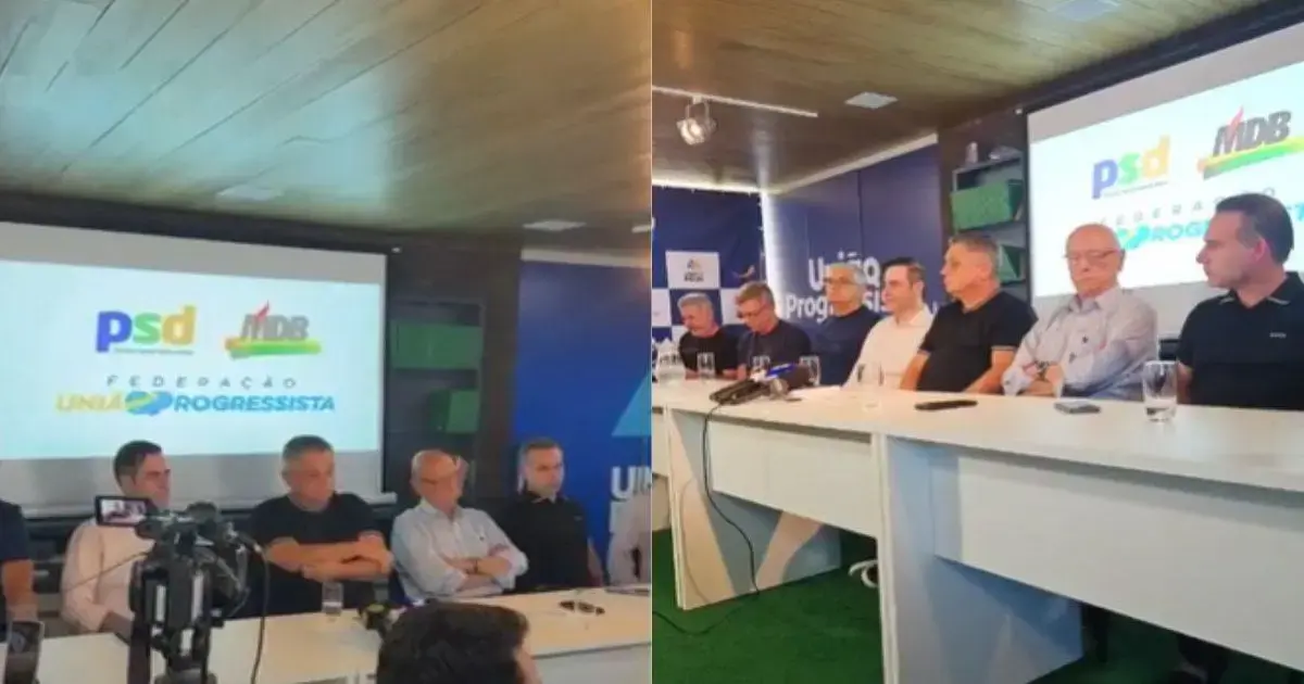 Reunião de representantes de partidos políticos com mesa, microfones e logotipo da federação no fundo.