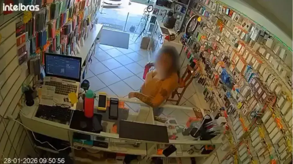 Ambiente de loja com balcão de atendimento, computador, e parede recheada de capas de celular.