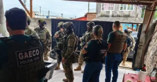 Grupo de policiais civis e militares em operação em uma área urbana, discutindo estratégias.