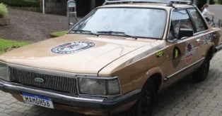 Carro Ford Del Rey 1982, pintado de dourado, com adesivos e placas visíveis.