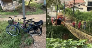Bicicletas encostadas em um terreno com um caminhão de bombeiros e pessoas próximas a uma ponte de arame.