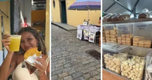 Mulher segurando um copo de bebida e um salgado, com barraca de venda de panos e doces ao fundo.