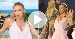 Duas mulheres com roupas elegantes durante um desfile, uma delas acenando para o público.