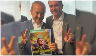 Duas pessoas fazem sinal de paz, uma segurando um cartaz do Partido Liberal com "Flávio Bolsonaro 2026".